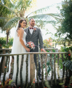 wedding couple standing on tropical setting posing for a photo.